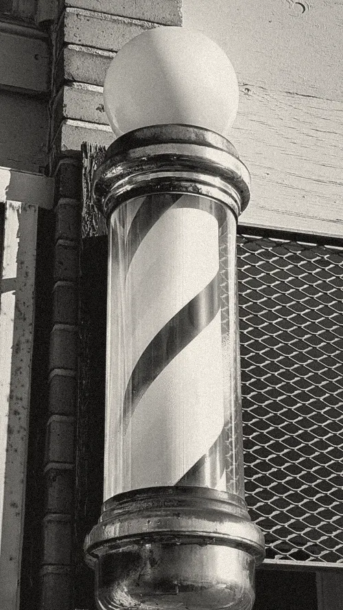 Poste de barbero en una fachada (foto ilustrativa)